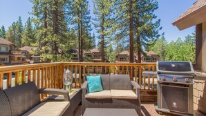 A deck with wicker furniture, a grill, and a view of surrounding houses. - Air Conditioning, Shuffleboard, Walk to Heavenly/ Casinos/ Lake, Grill, Wifi – Tahoe Woods Luxury (South Lake Tahoe)