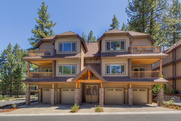 A multi-story residential building with a symmetrical facade, multiple balconies, and a central entrance with a decorative arch.