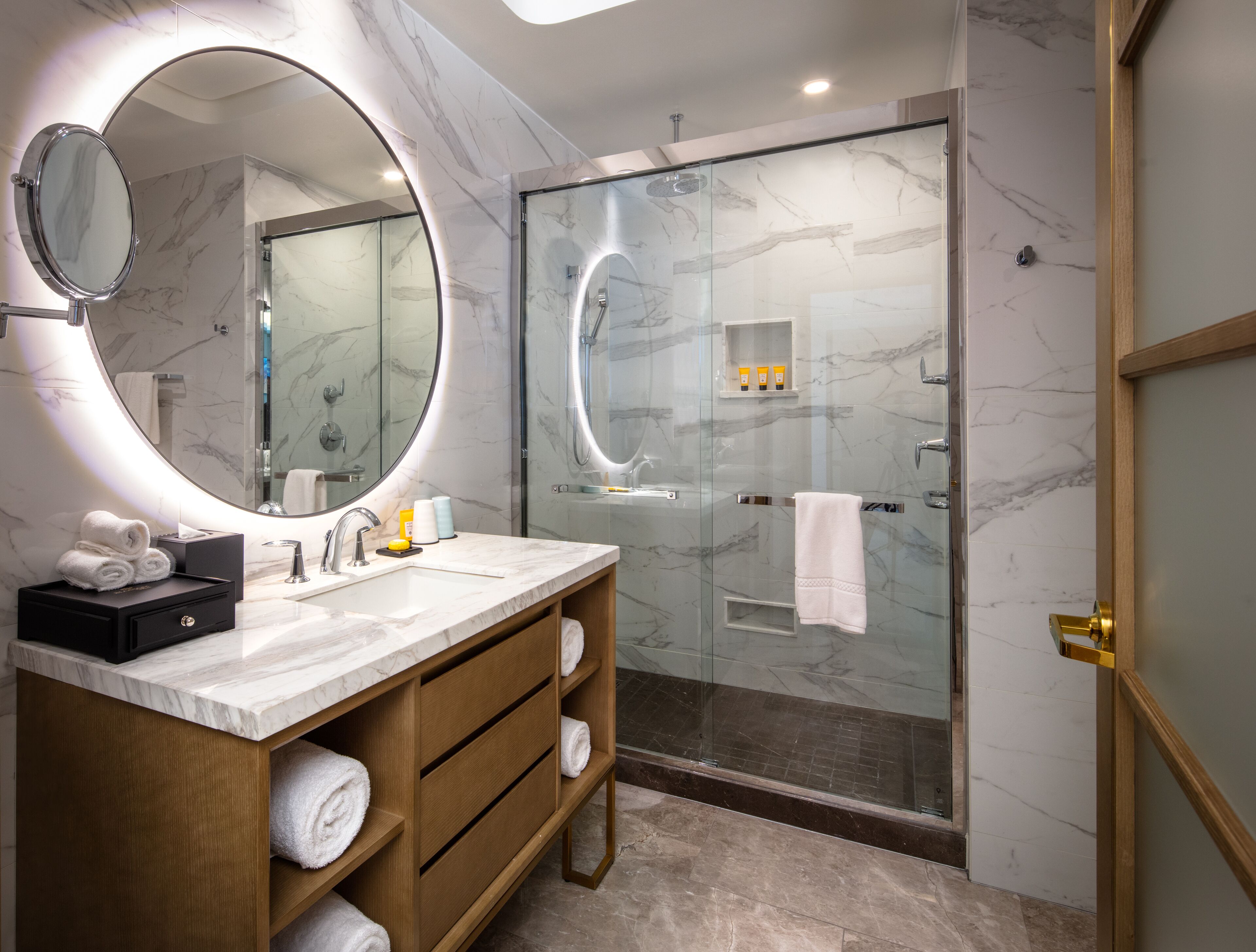 Een bad/douchecombinatie, een regendouche, designer toiletartikelen
