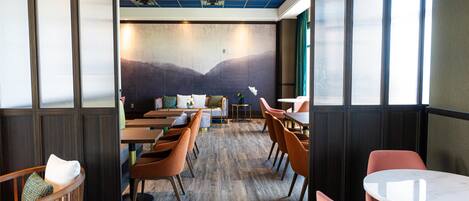 Un restaurante con suelo de madera, sillas anaranjadas y techo azul.