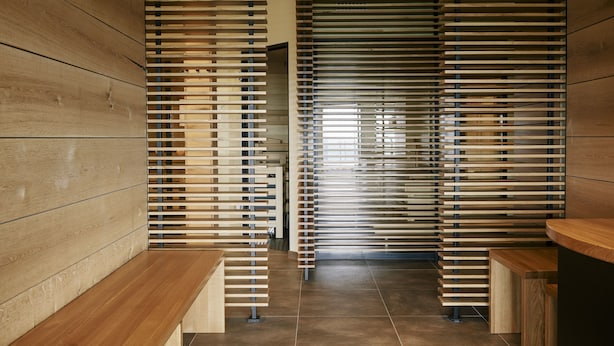 Een modern interieur met houten paneelwanden, een centrale bank en een betegelde vloer.