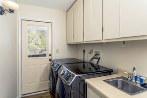 A compact laundry area with a washing machine, dryer, and sink.
