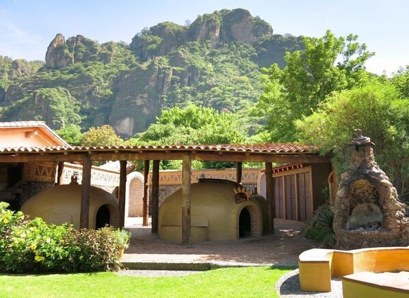 A courtyard with a stone structure, arches, and a statue.