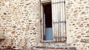 A stone building with a wooden door and steps leading to a porch. - Pyrenean Paradise (Castelnou)