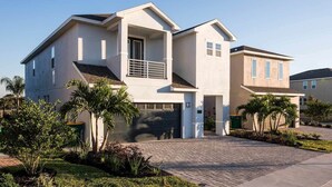 A two-story house with a garage, a balcony, and a driveway.