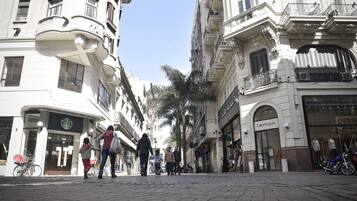 Una strada pedonale con edifici, uno Starbucks e un negozio chiamato 'lemon'.
