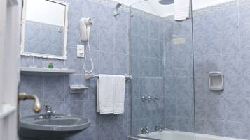 Un baño con lavabo, espejo, secador de pelo y ducha.
