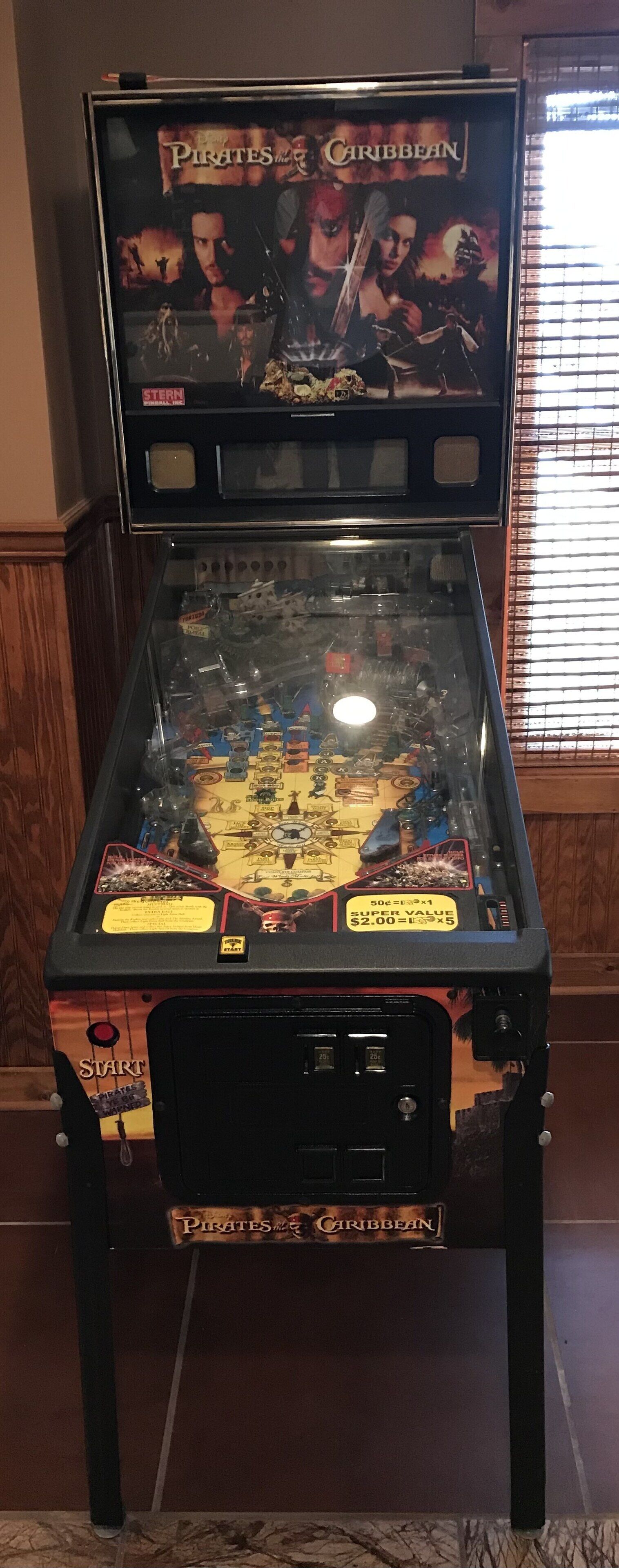 A pinball machine themed around 'Pirates of the Caribbean' with a 'Super Value' label and a '50¢=1' play value.