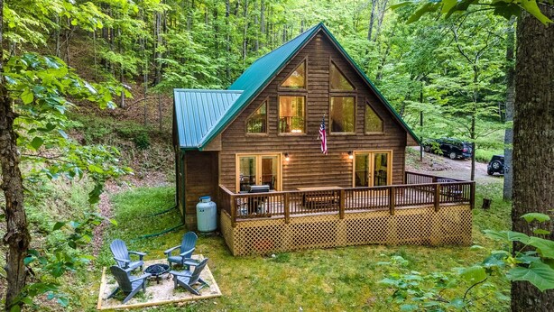 Eine Hütte mit einer Terrasse, umgeben von Wald.