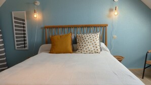 A bed with a wooden headboard, two pillows, and a white bedspread.