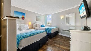 A hotel room with two beds, a TV, a desk, and a window with blinds. - Pelican Pointe 223:Walk to Beach~Pool~Free Parking (Clearwater Beach)