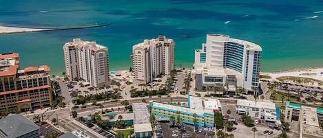 A coastal cityscape with high-rise buildings, a marina, and a beach.