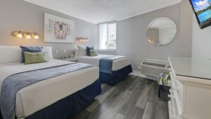 A hotel room with two beds, a large window, a wall-mounted mirror, and a TV. - Pelican Pointe 227:Walk to Beach~Pool~Free Parking (Clearwater)