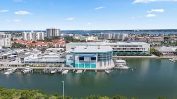 Marina com barcos atracados, um edifício com fachada azul e branca e vista ampla da paisagem urbana ao redor.