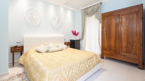 A bedroom with a bed, a wooden wardrobe, and a nightstand. - Superior Suite (St. Peter Vatican Bambino Gesù Gianicolo) (ROMA)
