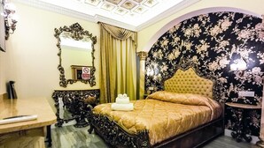 A bedroom with a large bed, ornate furniture, and a floral wallpaper design. - Executive Suite room (Roma)