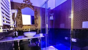 A modern bathroom with a glass-enclosed shower, a large ornate mirror, and a white sink. - Executive Suite room (Roma)