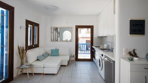 Eine moderne Wohnung mit Wohnzimmer, Küche und Waschbereich.