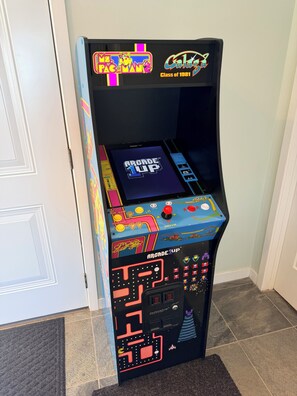 Una macchina arcade vintage con uno schermo che mostra il marchio 'Arcade 1UP' e 'Pac-Man'.