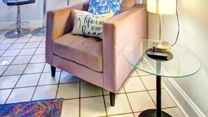 A living room with a sofa, two armchairs, a glass coffee table, a TV mounted on the wall, and a window with blinds. - Studio 301 Little Paris 1 blk to the beach 1floor (Fort Lauderdale)