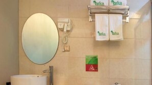 A bathroom with a round mirror, a sink, a toilet, and a towel rack with two towels.