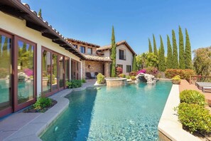 A modern house with a swimming pool, stone walls, and a garden with tall trees and shrubs. - Villa Vista de Rancho Santa Fe w/Pool, Views! (Escondido)