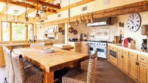 Una cocina amplia con vigas de madera, una estufa grande y un reloj en la pared.