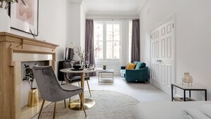 A modern living room with a fireplace, a dining area, and a sofa. - The Chelsea Studio next to Sloane Square (London)
