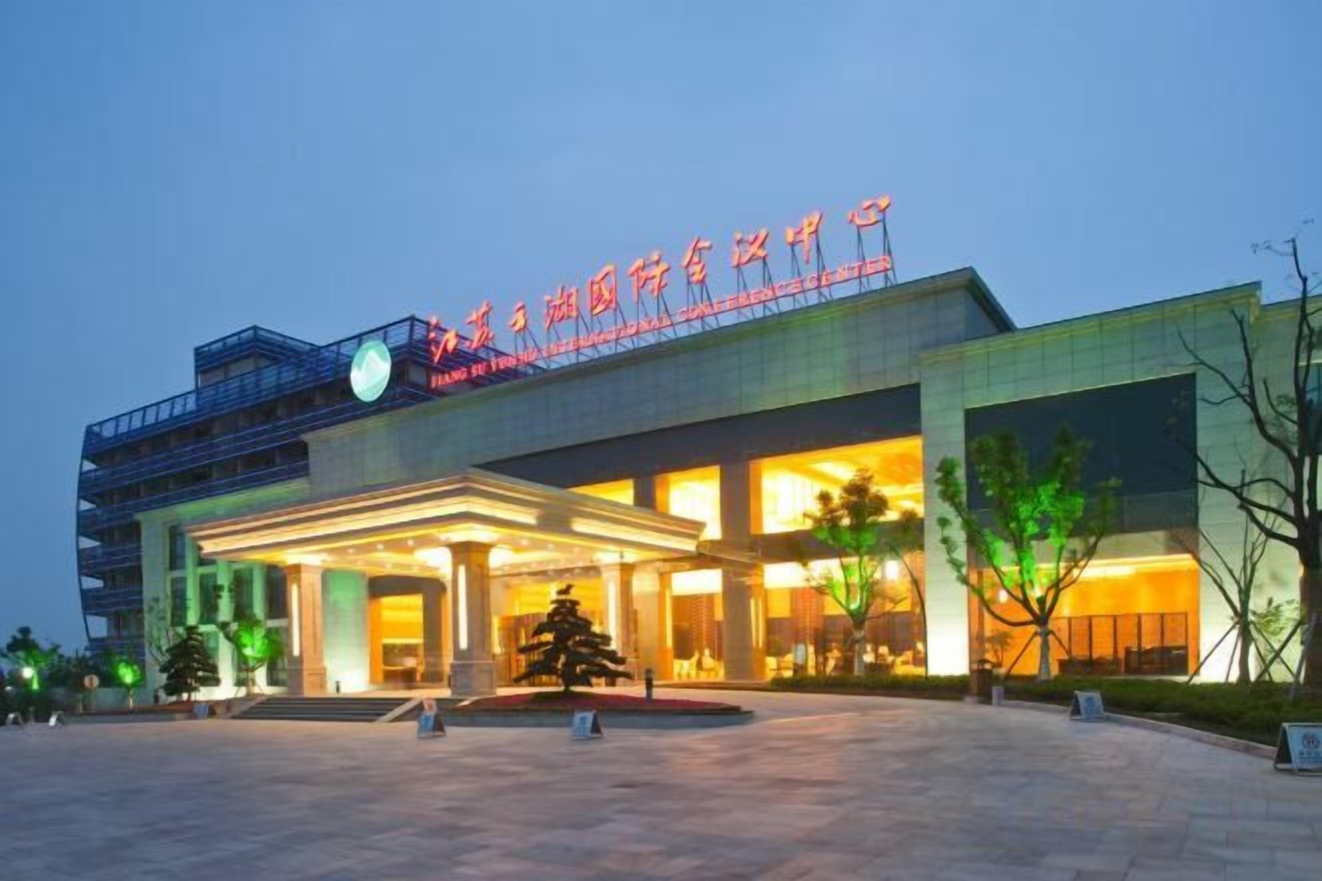 A hotel with a prominent entrance, a covered outdoor area, and a large sign above the entrance.