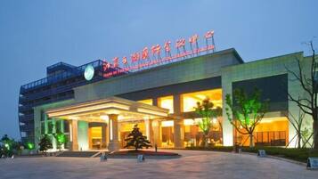 A hotel with a prominent entrance, a covered outdoor area, and a large sign above the entrance.