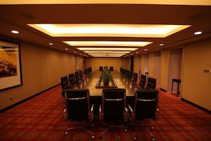 A conference room with a long table, chairs, and a carpeted floor. - Jiangsu Yunhu International Conference Center (Yixing)
