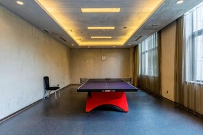 A room with a ping pong table, a chair, and a large window. - Jiangsu Yunhu International Conference Center (Yixing)
