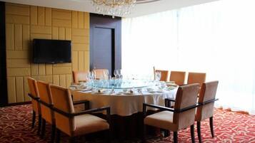 A dining room with a round table, chairs, and a chandelier.