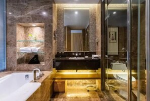 Un baño moderno con tocador de mármol, cabina de ducha de vidrio y bañera independiente.