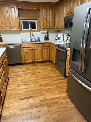 A kitchen with wooden cabinets, stainless steel appliances, and a window above the sink. - lake close (Mount Ida)