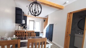 A modern kitchen with a central island, wooden chairs, and a chandelier. - ❤ Modern Rustic 2BR 2BTH Mountain Chalet close to Banff (Harvie Heights)