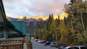 A parking lot with cars and a building with a green roof. - ❤ Modern Rustic 2BR 2BTH Mountain Chalet close to Banff (Harvie Heights)