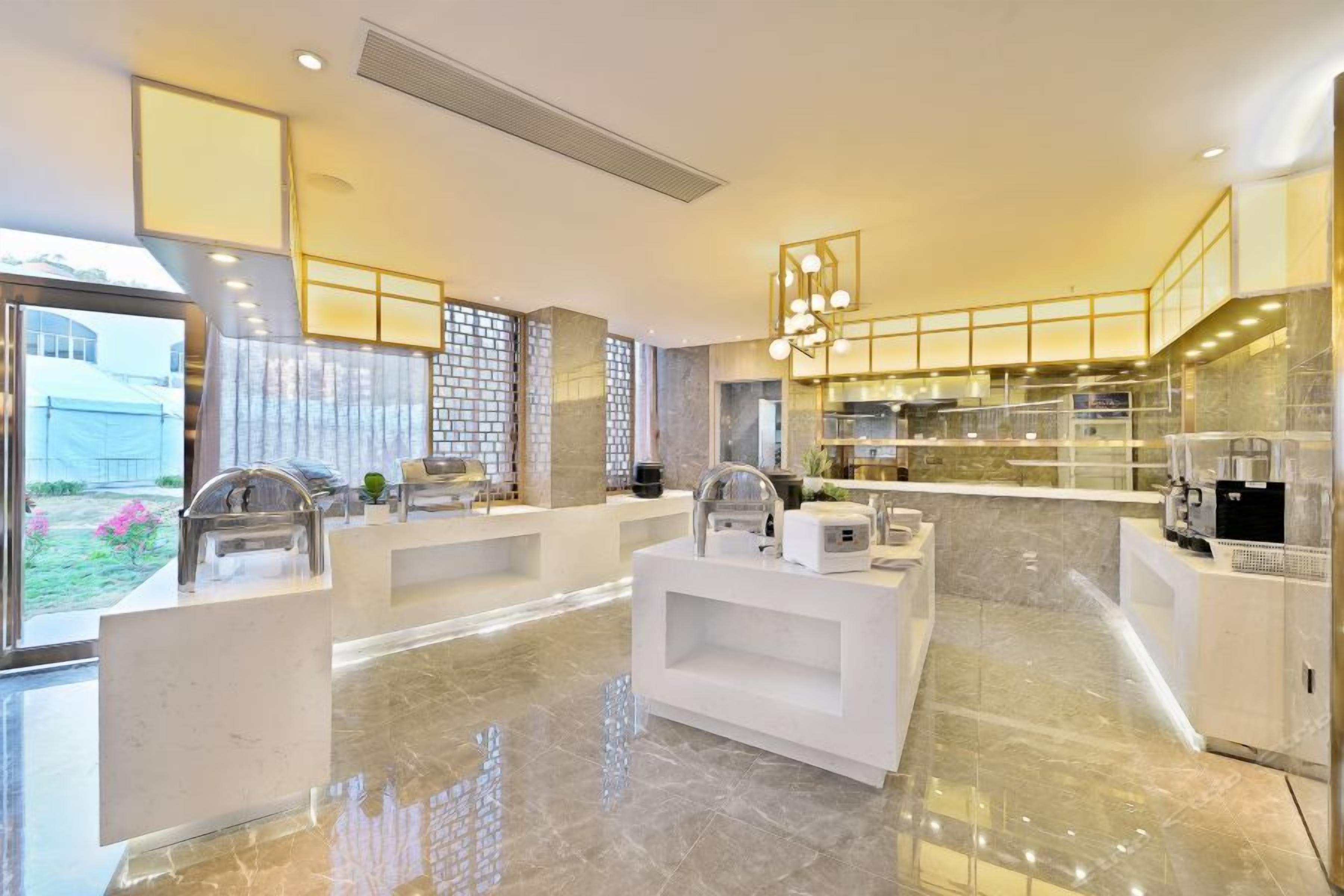 A modern kitchen with marble countertops, stainless steel appliances, and a central island.