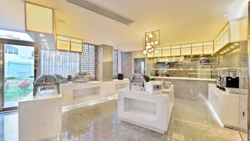 A modern kitchen with marble countertops, stainless steel appliances, and a central island.