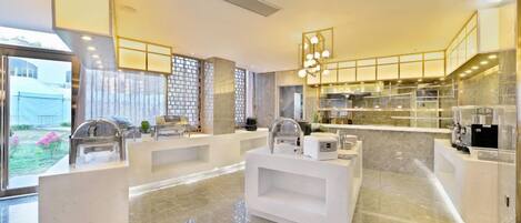 A modern kitchen with marble countertops, stainless steel appliances, and a central island.