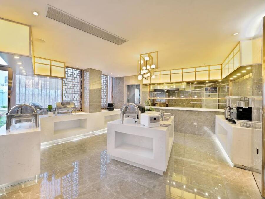 Une cuisine moderne dotée de plans de travail en marbre, d’appareils électroménagers en acier inoxydable et d’un îlot central.