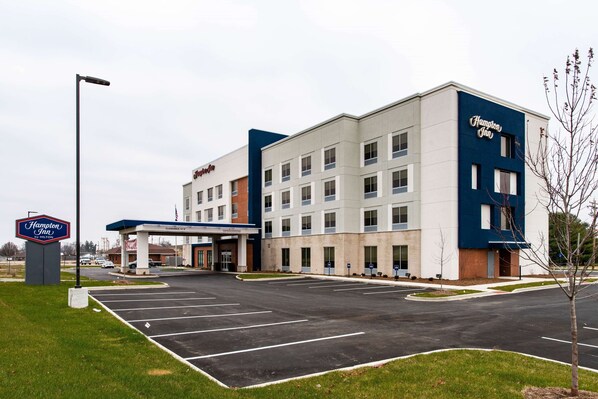 A Hampton Inn hotel with a parking lot and a gas station.