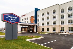 A Hampton Inn by Hilton hotel with a clear entrance, parking lot, and a modern building facade.