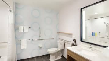 Une salle de bain moderne équipée de toilettes, d’un lavabo et d’une douche.