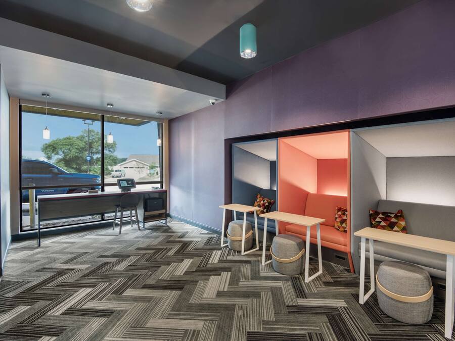 A modern interior with a herringbone carpet, a sofa, a table, and a bench.