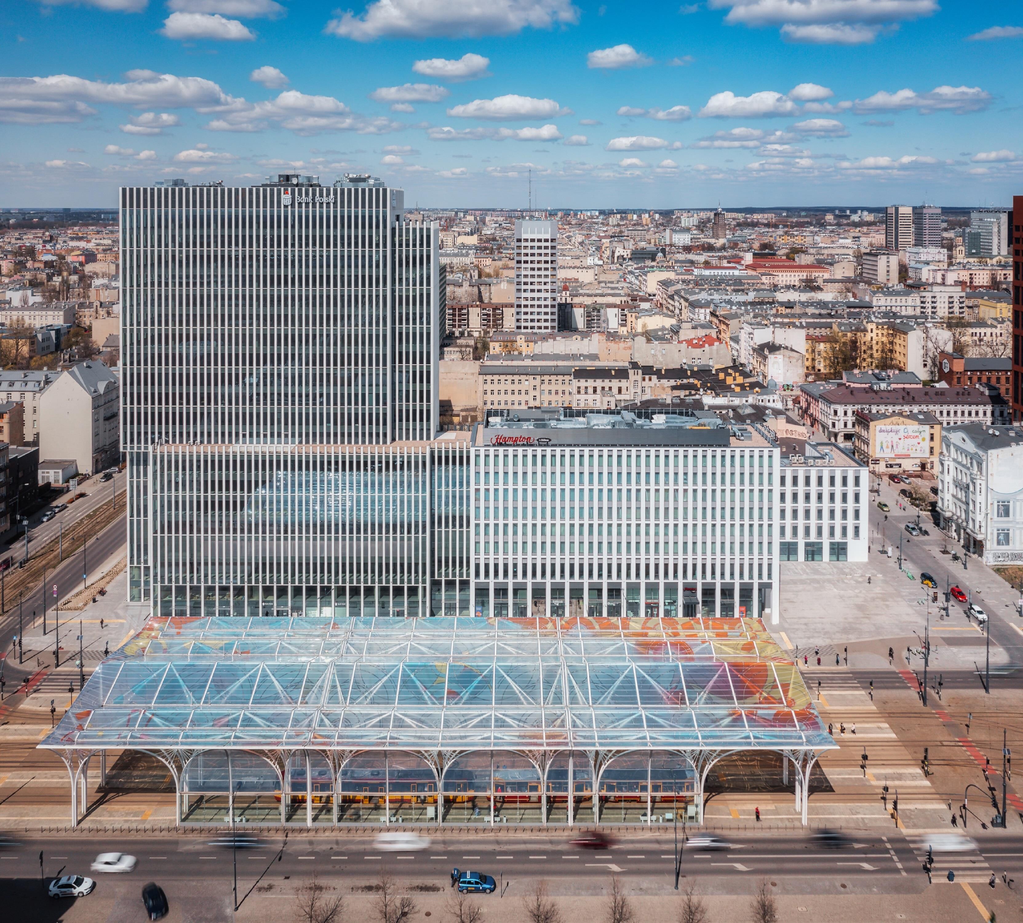 A modern building with a glass facade and a covered pedestrian area.