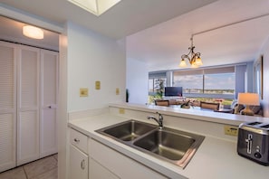 Une cuisine moderne dotée d’un évier à deux bacs, d’un grille-pain et offrant une vue sur l’extérieur.