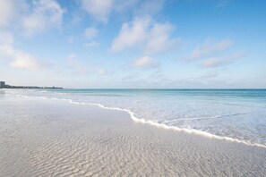 A beach with a clear sky and gentle waves. - This 2 bedroom 2 bathroom second floor condominium is located on the Gulf side of our property. (Sarasota)
