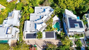 An aerial view of a residential area with multiple houses, some with solar panels, surrounded by lush greenery. - Upper Hastings Penthouse 5 Noosa Heads (Noosa Heads)