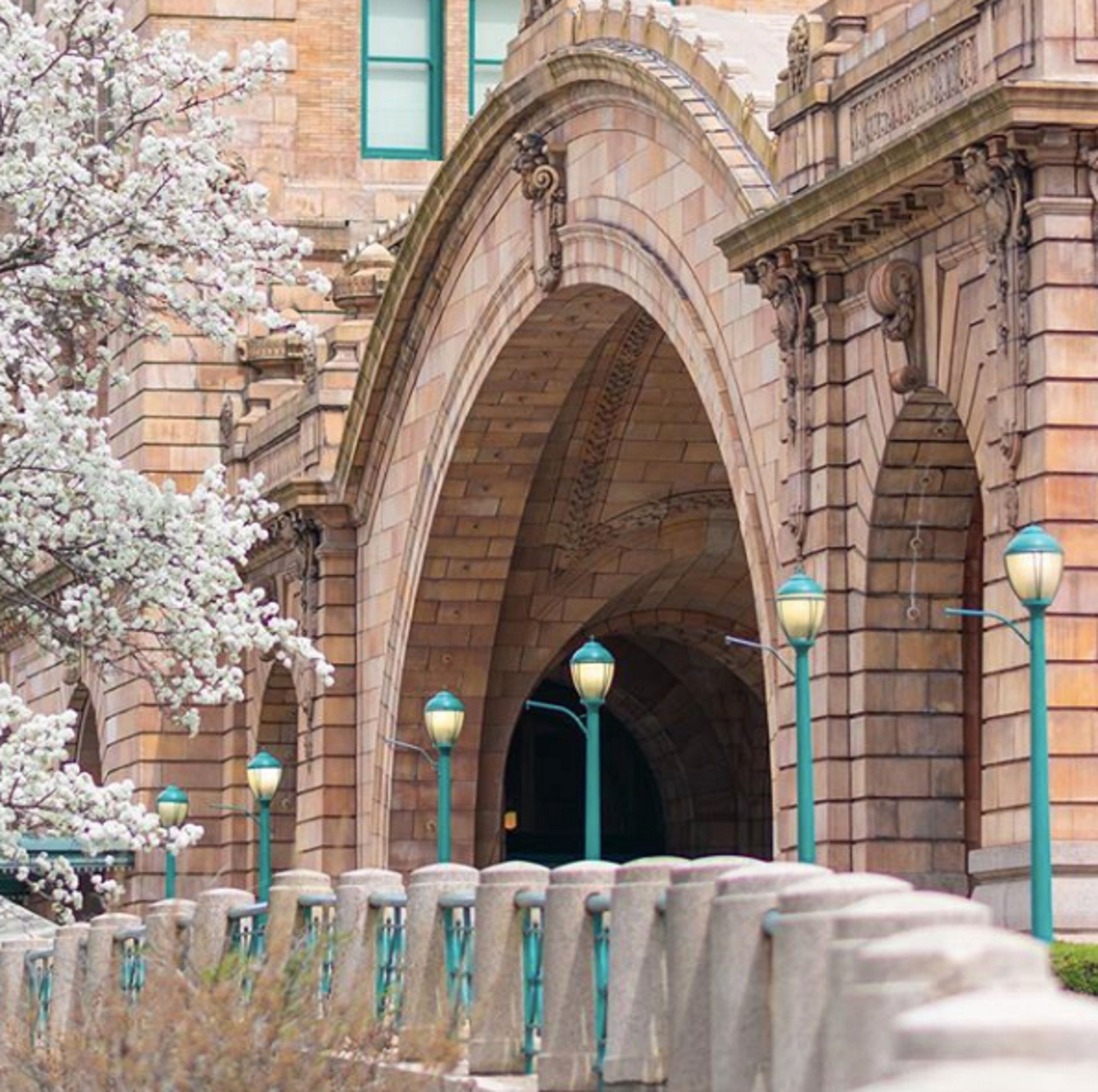 Un bâtiment historique doté d’entrées en arc de cercle et de lampadaires de style traditionnel.